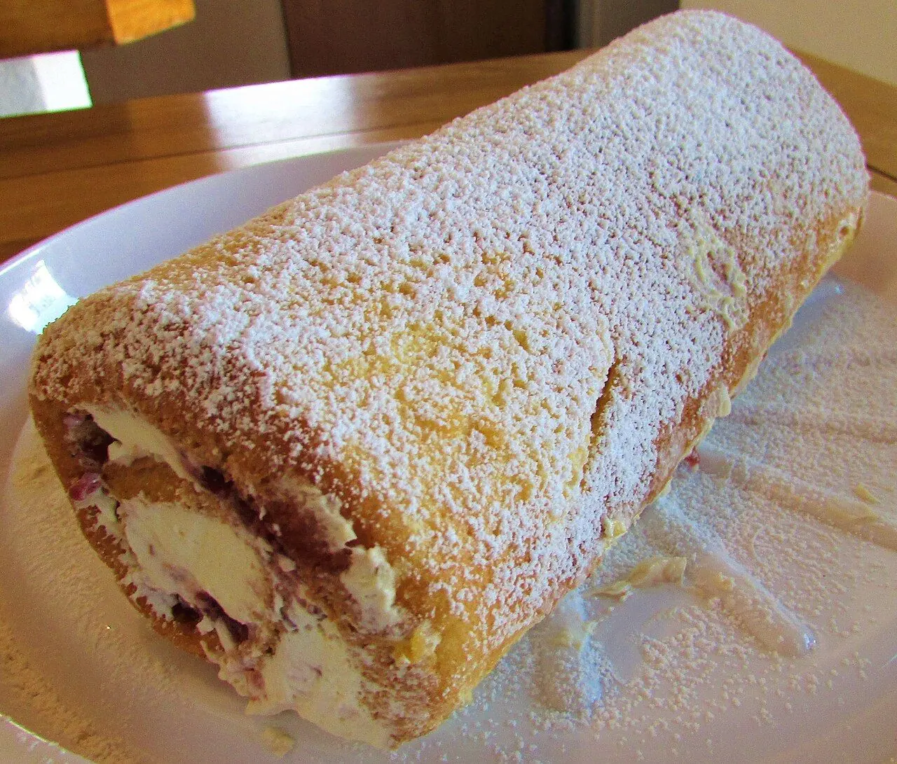 A homemade strawberry swiss roll cake made in a kitchen in the village of Trimingham , Norfolk, United Kingdom.